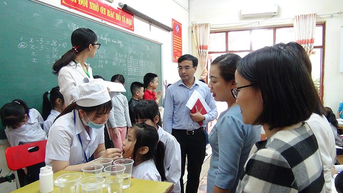 Cán bộ Y tế cho trẻ uống thuốc tẩy giun tại Trường Tiểu học Hạ Long (thành phố Hạ Long, Quảng Ninh) - (Ảnh: Minh Khương)
