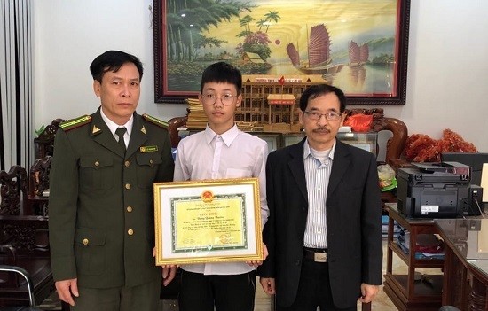 Lãnh đạo Hạt kiểm lâm thành phố Móng Cái tặng giấy khen của Sở Nông nghiệp và Phát triển nông thôn Quảng Ninh cho em Đặng Quang Trường (Ảnh: CTV)