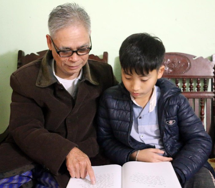 Thầy giáo Phạm Văn Tân vẫn dành nhiều thời gian chăm sóc, dạy dỗ các cháu học hành (Ảnh: Công Quý)