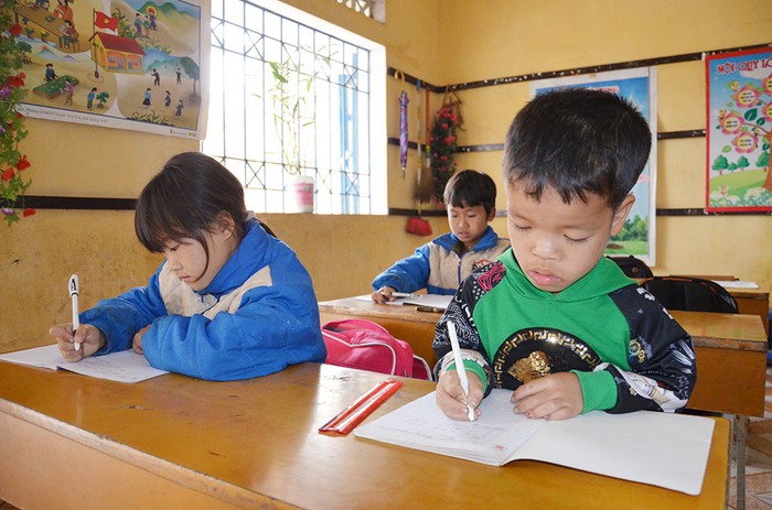 Nhờ sự quan tâm, chỉ bảo tận tình của cô giáo Lã Thị Nhung, em Vi Xuân Cảnh (bên phải) ngày càng tiến bộ (Ảnh: Lan Anh)