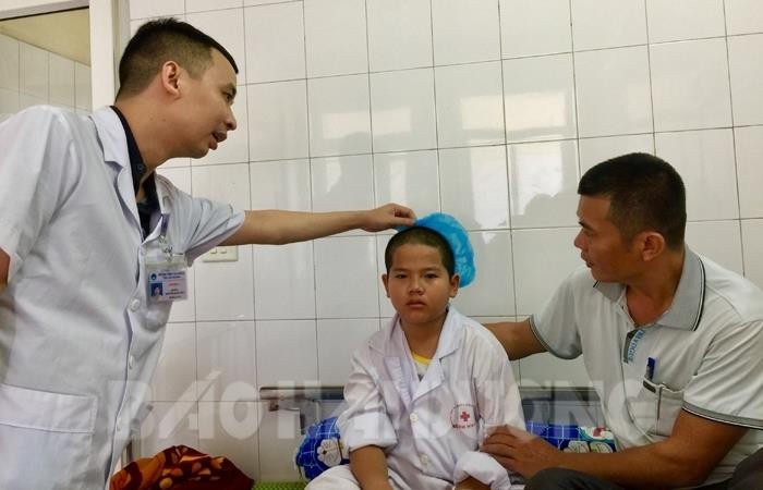 Bác sĩ khoa Ngoại 2 (Bệnh viện Đa Khoa tỉnh Hải Dương) kiểm tra tình hình sức khoẻ của em Sơn trước khi xuất viện. (Ảnh: Báo Hải Dương)
