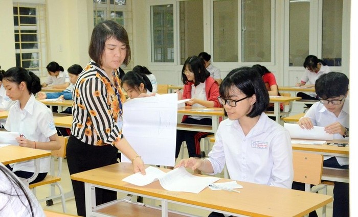 Giám thị phát giấy thi, giấy nháp cho các thí sinh tại điểm thi Trường Trung học phổ thông Uông Bí (Ảnh: Nguyễn Thanh)