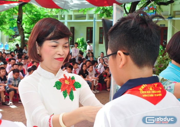 Cô giáo Lê Thị Minh Tâm, Hiệu trưởng Trường Trung học cơ sở Tô Hiệu trao khăn quàng tiếp lửa cho học sinh khối 6 (Ảnh: Quyết Cương)