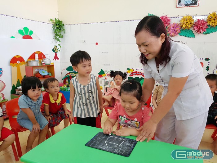 Cô giáo Phạm Thị Thanh dạy trẻ lớp 4 tuổi tập vẽ (Ảnh: Lã Tiến)