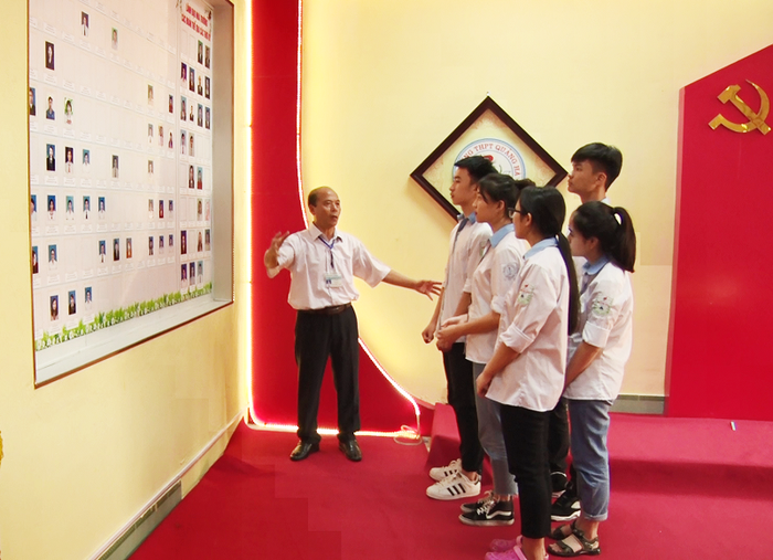 Thầy giáo Vũ Viết Sử cùng với các em học sinh lớp 12A1 ôn lại truyền thống lịch sử qua các thời kỳ của trường Trung học phổ thông Quảng Hà (Ảnh: CTV)