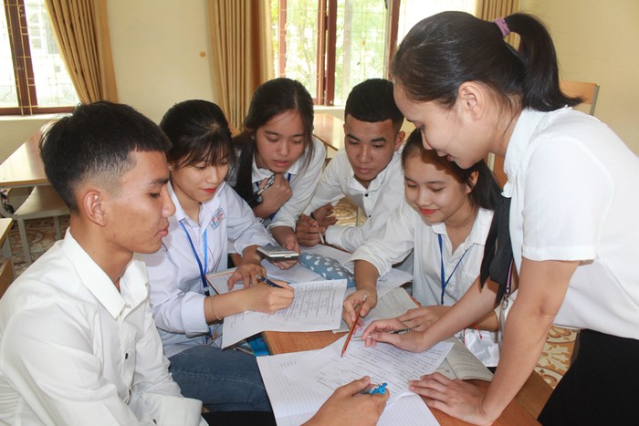 Tranh thủ giờ lên lớp, cô giáo Lê Thị Hải Yến (ngoài cùng bên phải) hỗ trợ thêm kiến thức cho học sinh (Ảnh: Phạm Tuyết)