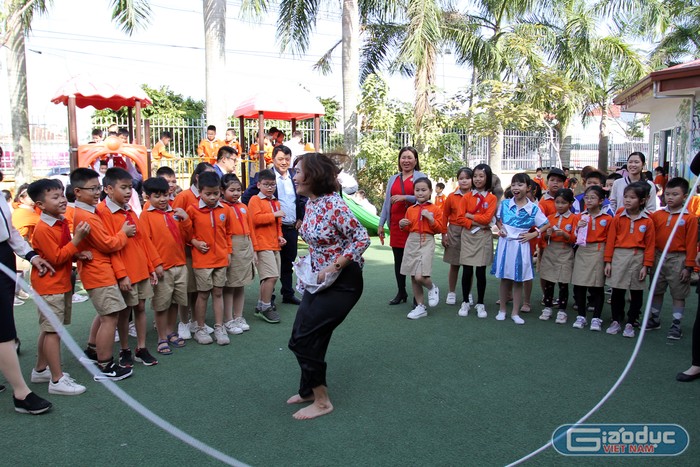 Cô giáo Vũ Thị Kim Vân, Hiệu trưởng Trường Tiểu học Hải Thành tham gia các trò chơi dân gian với các em học sinh (Ảnh: Lã Tiến)