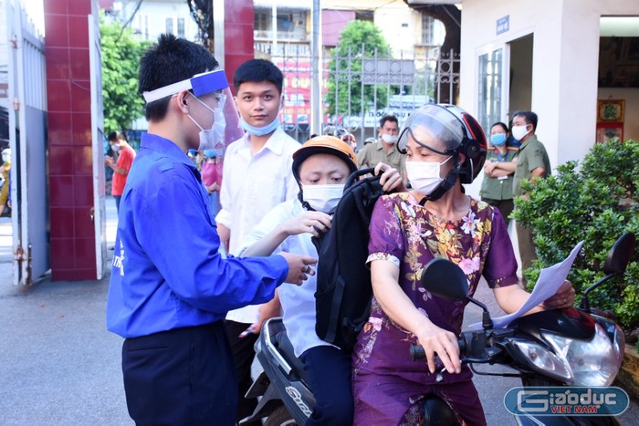 Em Nguyễn Đức Quân, học sinh lớp 12A13, trường Trung học phổ thông Thái Phiên (quận Ngô Quyền, Hải Phòng) bị bệnh "xương thủy tinh" được mẹ chở đến trường dự thi. (Ảnh: Lã Tiến)