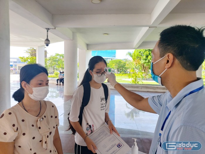 Phụ huynh, học sinh tới Trường Trung học phổ thông chuyên Trần Phú làm thủ tục nhập học được đo thân nhiệt và sát khuẩn tay (Ảnh: Lã Tiến)