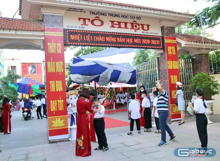 Lãnh đạo Trường Trung học cơ sở Tô Hiệu đón và chỉnh sửa trang phục cho học sinh dự khai giảng ngay tại cổng trường (Ảnh: MT)
