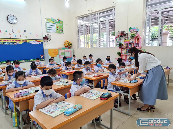 Giáo viên Trường Tiểu học Đinh Tiên Hoàng dạy học trò tư thế ngồi học, đọc sách (Ảnh: Lã Tiến)