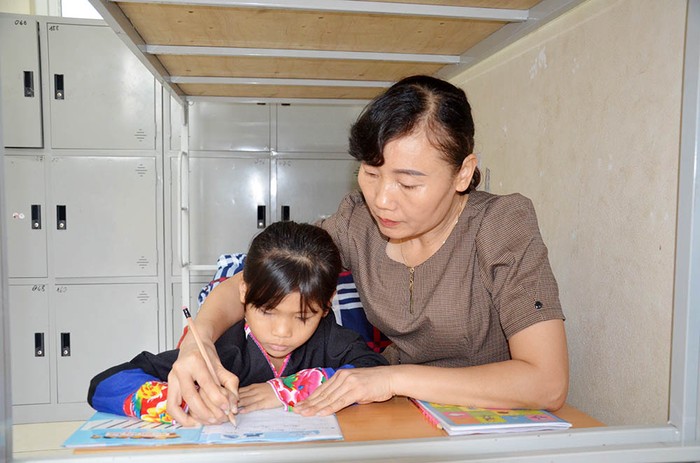 Cô giáo Tô Thị Miên hướng dẫn học sinh lớp 1 viết chữ (Ảnh: CTV)