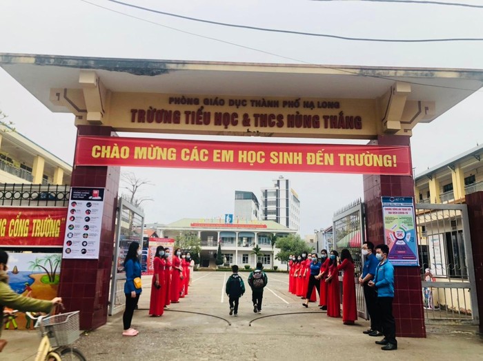 Giáo viên Trường Tiểu học và Trung học cơ sở Hùng Thắng (thành phố Hạ Long) đón học sinh ngoài cổng trường (Ảnh: CTV)