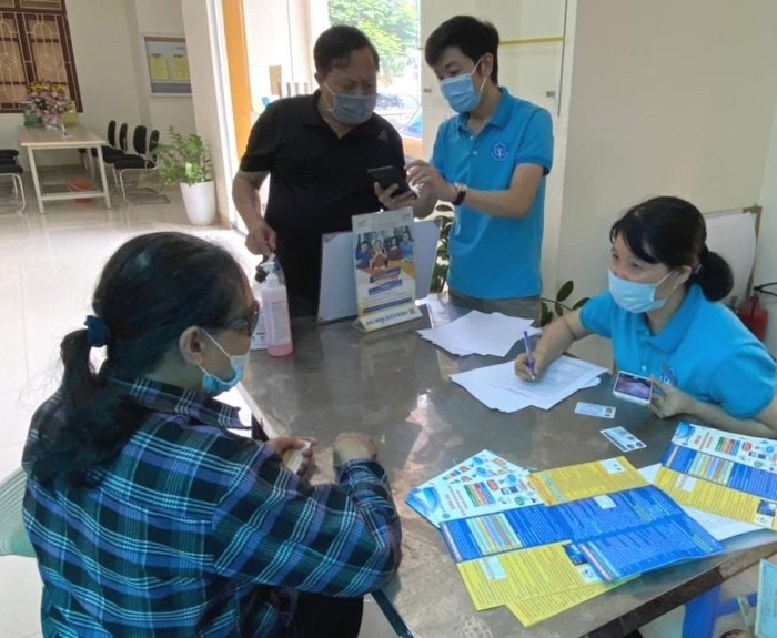 Cán bộ Bảo hiểm xã hội Quảng Ninh hướng dẫn người dân cài đặt phần mềm VssID (Ảnh: CTV)