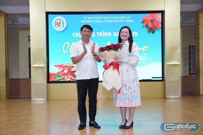 Ông Phạm Văn Khanh - Bí thư Quận uỷ Kiến An tặng hoa, chào đón em Nguyễn Thị Thạch Thảo trở về mái trường xưa (Ảnh: LT)