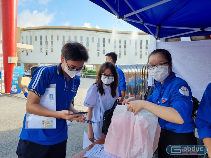 Lực lượng tình nguyện viên hỗ trợ các thí sinh gửi đồ và nhắc nhở kiểm tra các vật dụng khi mang vào phòng thi (Ảnh: Lã Tiến)
