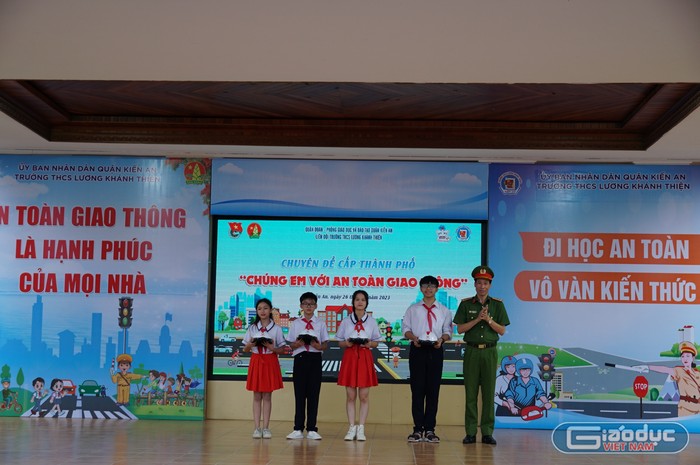 Lãnh đạo Công an quận Kiến An trao mũ bảo hiểm tặng học sinh nhà trường (Ảnh: LT)