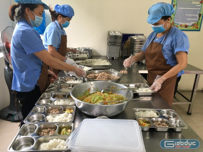 Nhân viên nhà bếp trường Tiểu học Thành Tô chia suất ăn cho học sinh (Ảnh: LT)