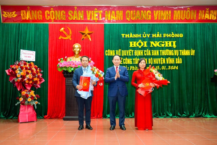 Ông Lê Tiến Châu - Bí thư Thành ủy Hải Phòng trao Quyết định và tặng hoa chúc mừng ông Nguyễn Hoàng Long và bà Phạm Tuyên Dương (Ảnh: HT)