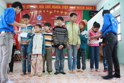 Bạn Đỗ Ngọc Tân, trưởng Ban tổ chức tặng học bổng cho 11 em ở trung tâm có thành tích học tập xuất sắc.
