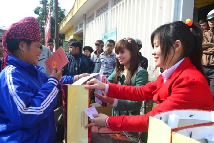 Nguyễn Thị Minh Khuê (phải) trao quà cho người dân trong chuyến từ thiện Tây Bắc cùng báo GDVN