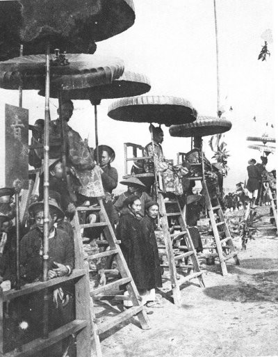 Các quan chủ khảo ngồi trên một chiếc ghế cao dưới lọng để quan sát các thí sinh làm bài. Ảnh chụp tại trường thi Nam Định năm 1897.
