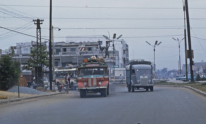 Sài Gòn 1969 - Bùng binh Cây Gõ, còn gọi là công trường Duy Linh.. Giữa vòng xoay Cây Gõ là tượng đài Lê Lợi. Loại xe đò màu đỏ Hotchkiss của Pháp rất phổ biến thời đó, dân tình thường gọi là "xe đò mỏ nhọn" - Ảnh. George Lane.