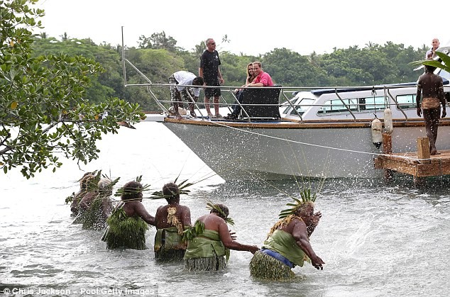 9 người phụ nữ trong trang phục truyền thống đứng dưới nước thực hiện nghi lễ té nước truyền thống.