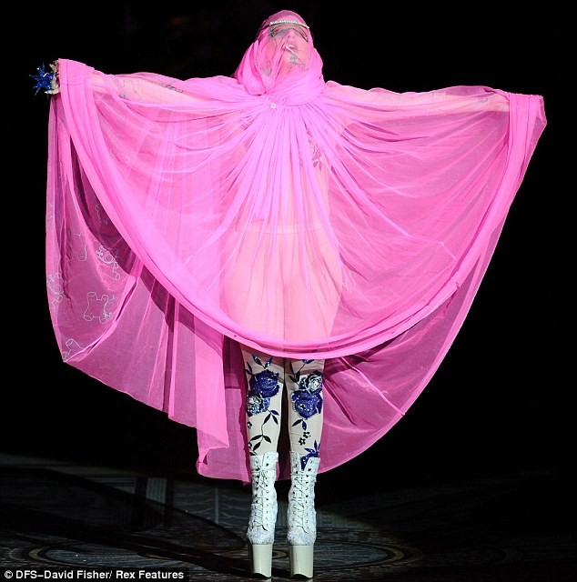 Trước đó, nữ ca sĩ quái chiêu đã mở màn show diễn của NTK Phillip Treacy bằng trang phục áo choàng hồng phủ toàn bộ cơ thể với đôi guốc mang “thương hiệu” Gaga. Ảnh. Rex.