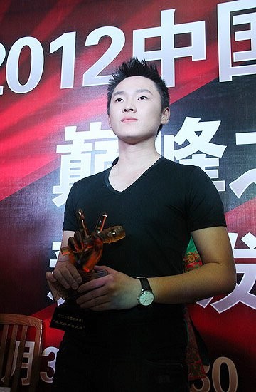 Quán quân The Voice Trung Quốc 2012 Lương Bác với kỷ niệm chương của The Voice cho người chiến thắng.