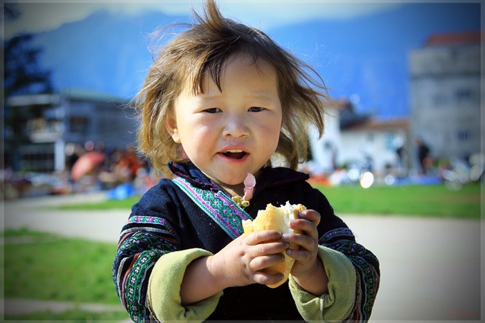 Một em bé người H'Mong đen ở thị trấn Sapa, Lào Cai với mẩu bánh mì.