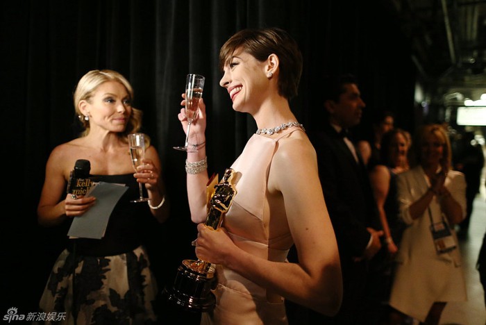 Nữ diễn viên Anne Hathaway (phải) mừng chiến thắng với tượng vàng Oscar cho Nữ diễn viên phụ xuất sắc nhất phim Những người khốn khổ. Đứng bên cạnh là MC truyền hình Kelly Ripa.