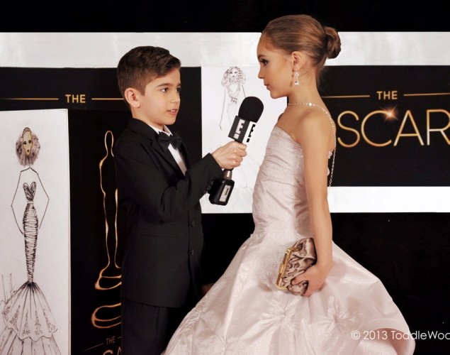 Hai người mẫu nhí diễn tả lại khoảnh khắc Ryan Seacrest (trái) phỏng vấn Jennifer Lawrence tại Oscar 85.
