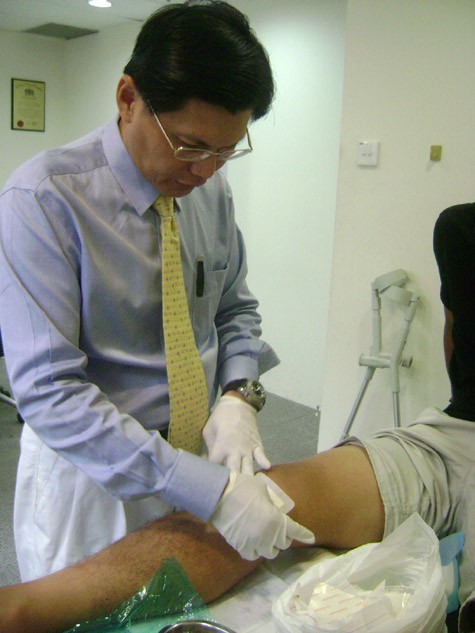 Bác sĩ Tan Jee Lim đang kiểm tra chấn thương của Quang Thanh.