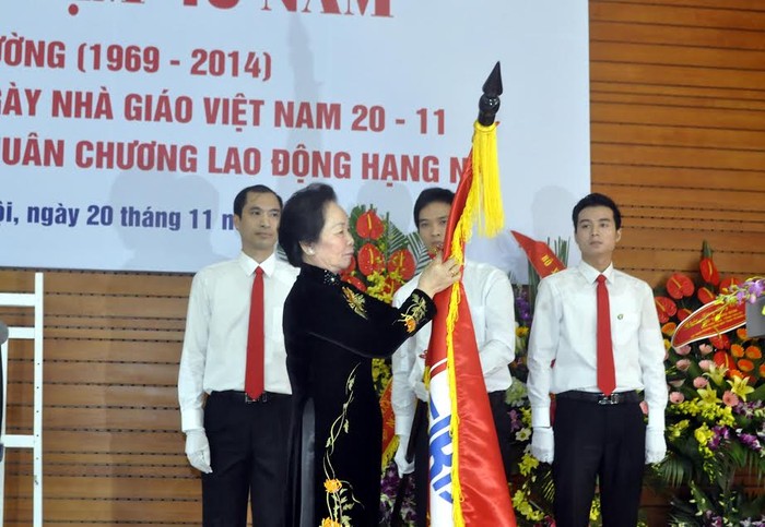 GS.TS Nguyễn Thị Doan, Ủy viên Trung ương Đảng, Phó Chủ tịch nước gắn Huân chương lên lá cờ truyền thống của Trường