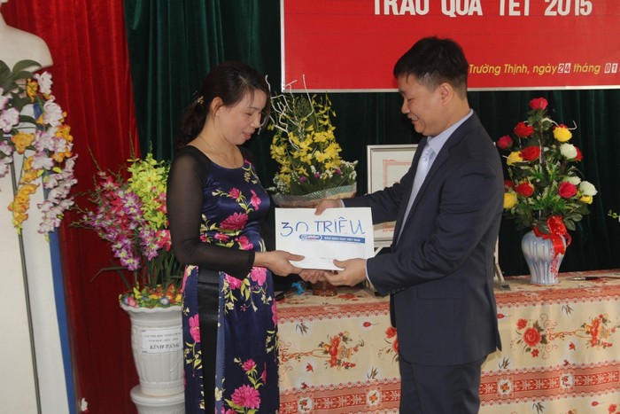 Cô Bùi Thị Bình - Hiệu trưởng, đại diện Trường Tiểu học Trường Thịnh nhận số tiền 30 triệu đồng hỗ trợ kinh phí xây dựng nhà ăn bán trú cho học sinh.