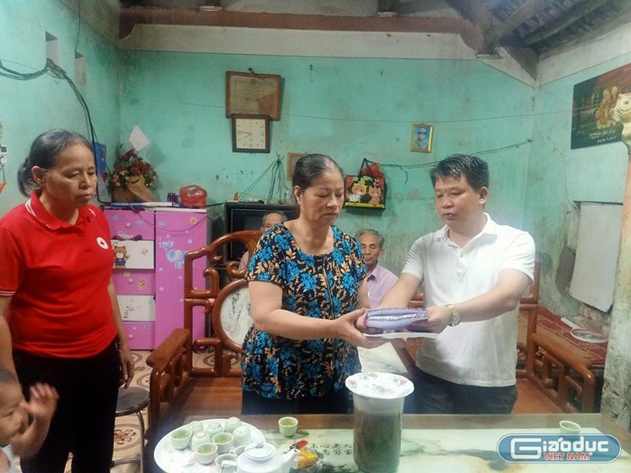 Ông Nguyễn Văn Oánh - Chủ tịch Ủy ban Nhân dân xã Văn Bình trao tiền quyên góp của các nhà hảo tâm cho người nhà của chị Thơm.
