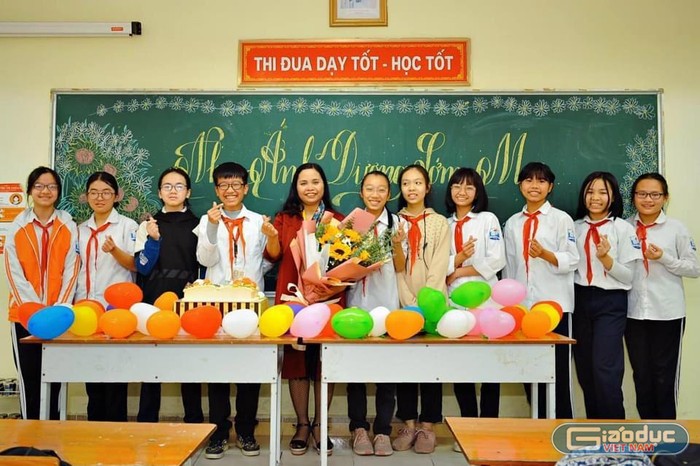 Hiệu trưởng trường Trung học cơ sở Mai Động - cô Nguyễn Thị Hà Thanh chụp ảnh lưu niệm cùng các học sinh. (Ảnh: NVCC)