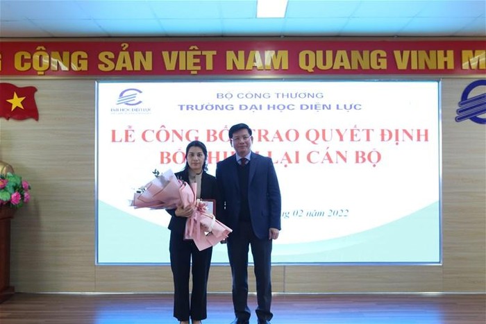 Phó giáo sư - Tiến sĩ Đinh Văn Châu trao quyết định và hoa cho viên chức được bổ nhiệm lại.