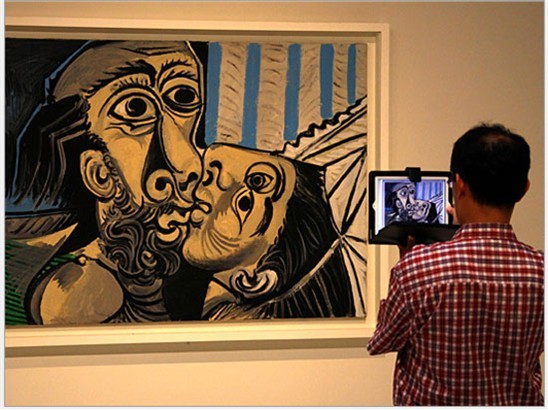 Khách tham quan dùng iPad để chụp lại bức tranh “The Kiss” tại triển lãm nghệ thuật của danh họa Pablo Picasso tại Triển lãm nghệ thuật Nam Úc – Sydney, Australia.