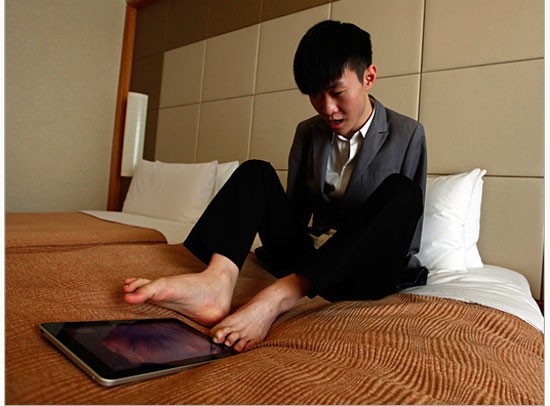 Liu Wei – thần đồng Piano trong cuộc thi China Got Talent – say sưa với chiếc iPad trước giờ thực hiện quảng cáo cho một kênh truyền hình địa phương tại Bắc Kinh.