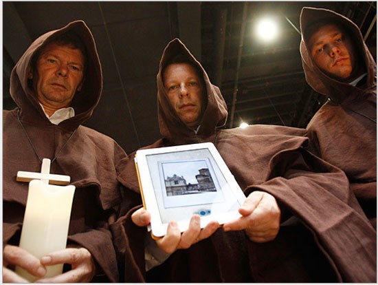 Những nhân viên nhà xuất bản Luebbe Digital cải trang như những thầy tu giữ trên tay chiếc iPad đang hiển thị hình ảnh cuốn tiểu thuyết nổi tiếng Apocalypsis (Bướm đêm) tại Hội chợ Sách Frankfurt ngày 13 Tháng Mười 2011.