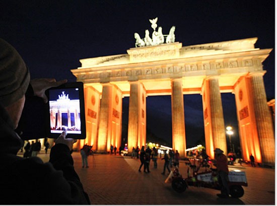 Một người đàn ông dùng iPad để chụp lại cổng Brandenburg lung linh trong Lễ hội Ánh sáng Berlin- Đức.