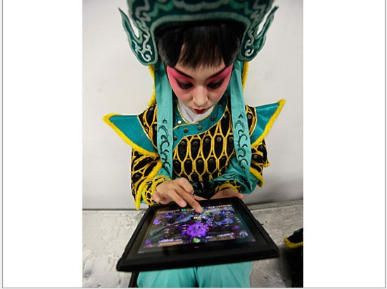 Một diễn viên Kinh kịch chơi game trên iPad trước giờ biểu diễn tại cuộc thi tìm kiếm diễn viên tài Bắc Kinh lần thứ nhất.