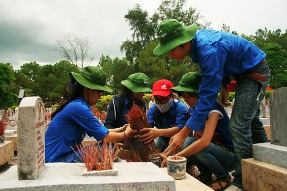 Các thành viên trong đội sửa sang, quét dọn các phần mộ liệt sĩ - Ảnh: Sơn Trương