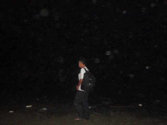 Một người nhà nạn nhân thẫn thờ đi dọc bờ biển gọi tên con mình trong đêm tối