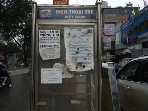 Mặt ngoài của cabin điện thoại công cộng luôn là nơi “lý tưởng” để dán các tờ quảng cáo (ảnh: Đăng Đức)
