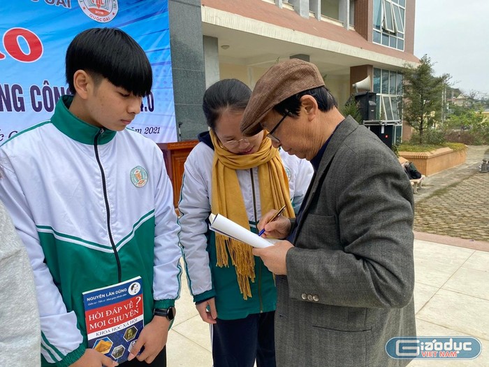 Giáo sư Nguyễn Lân Dũng ký tặng sach cho học sinh (Ảnh: Phạm Minh)
