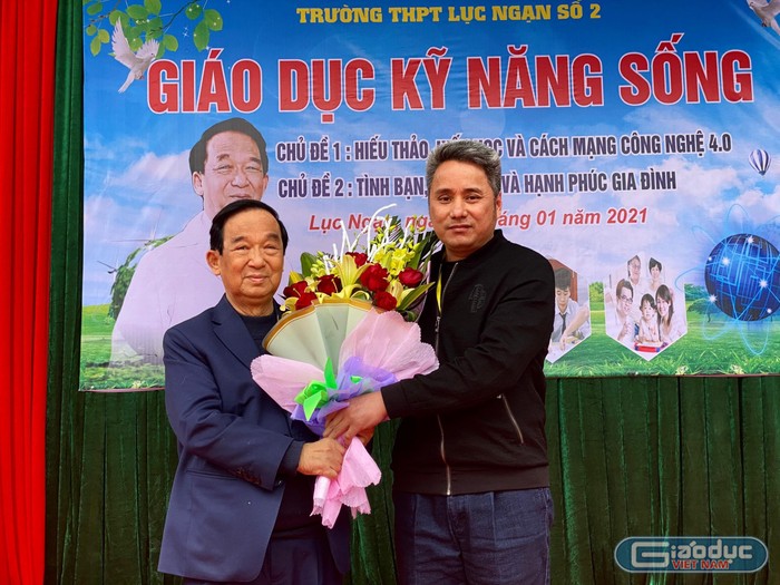 Thầy giáo Trần Văn Thi - Hiệu trưởng Trường Trung học phổ thông Lục Ngại số 2 tặng hoa và gửi lời cảm ơn đến Giáo sư Nguyễn Lân Dũng (Ảnh: Phạm Minh)