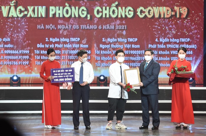 Thủ tướng Chính phủ Phạm Minh Chính trao chứng nhận cảm ơn em Lê Đức Hiếu, học sinh Trường Phạm Hồng Thái, Ba Đình, Hà Nội, 15 tuổi.